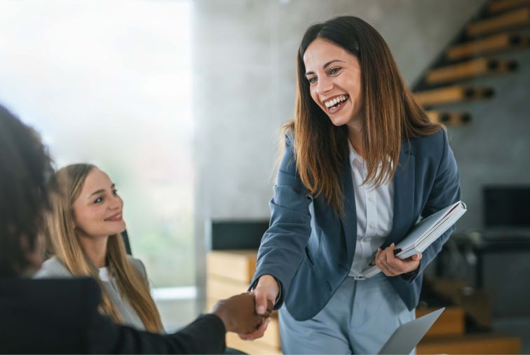 Business professionals greeting one another with a handshake during a meeting in a modern office setting